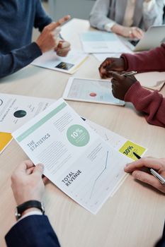 Colleagues discussing financial documents and statistics in an office setting.